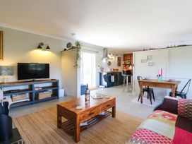 A living room with a tv, sofa, and dining area at The Annexe @ Shotley Cottage in Shotley Gate