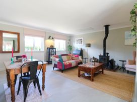 A living room with a sofa, table, and fireplace at The Annexe @ Shotley Cottage Shotley Gate