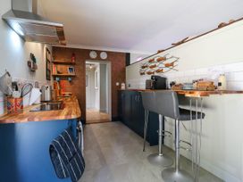 A kitchen with bar stools and kitchen counter at The Annexe @ Shotley Cottage in Shotley Gate