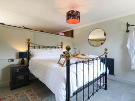 A bedroom with a bed, nightstand, lamp, mirror, and tray at The Annexe @ Shotley Cottage in Shotley Gate