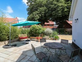 A garden with a table and chairs and an umbrella at The Annexe @ Shotley Cottage Shotley Gate