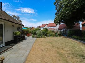 A garden with a lawn, patio furniture, and greenery at The Annexe @ Shotley Cottage in Shotley Gate