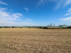A field with harvested crops and cranes in the distance at The Annexe @ Shotley Cottage Shotley Gate