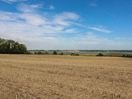 A field with trees and water in the background at The Annexe @ Shotley Cottage in Shotley Gate