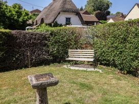 A garden with a bench and birdbath at Tane Winterborne Stickland