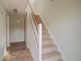 A hallway with a staircase and a rug at Tane in Winterborne Stickland