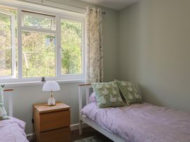 A bedroom with two beds and a lamp on a table at Tane in Winterborne Stickland