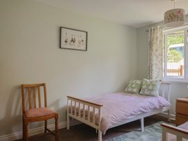 A bedroom with a bed and chair at Tane in Winterborne Stickland