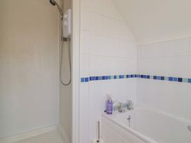A bathroom with a shower and bath tub at Tane in Winterborne Stickland