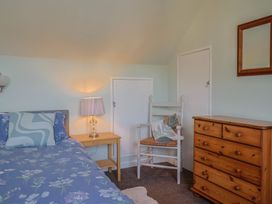 A bedroom with a bed and dresser at Tane in Winterborne Stickland
