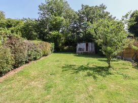A garden with grass and a shed at Tane in Winterborne Stickland