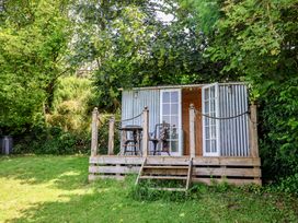 A garden shelter with wooden deck and chairs at Tane in Winterborne Stickland