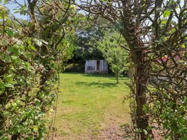 A garden view with a shed and seating area at Tane in Winterborne Stickland