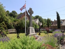 A garden with a memorial cross and benches at Tane in Winterborne Stickland