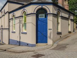 An exterior view of a building with a blue door and windows at Farthings, The Old Chapel in St. Austell