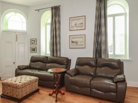 A living room with sofas and a side table at Farthings, The Old Chapel St. Austell