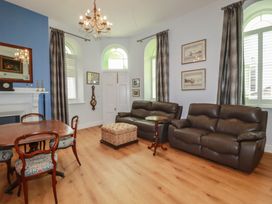 A living room with sofas and a table at Farthings, The Old Chapel St. Austell