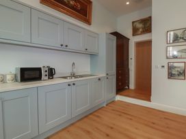 A kitchen with cabinets and appliances at Farthings, The Old Chapel St. Austell