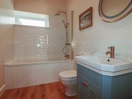 A bathroom with a bathtub, shower, sink, and toilet at Farthings, The Old Chapel in St. Austell