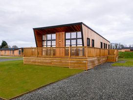 A lodge with decking and large windows at Exclusive Tempest Spa in Grimsby