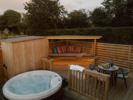 An outdoor seating area with a hot tub at Exclusive Tempest Spa in Grimsby