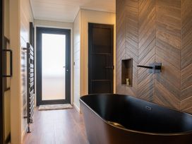 A bathroom featuring a bathtub and towel rack at Exclusive Tempest Spa in Grimsby