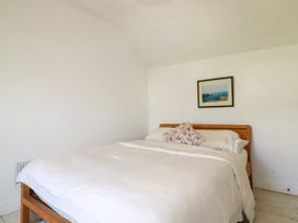 A bedroom with a bed and a picture at 18 Tregea Terrace in Portreath