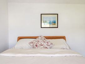 A bed with pillows and a picture on the wall at 18 Tregea Terrace in Portreath