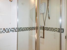 A shower with controls and tiles at 18 Tregea Terrace in Portreath