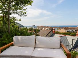 A sofa overlooking a view of the sea and houses at 18 Tregea Terrace Portreath