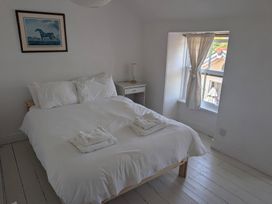 A bedroom with a bed and nightstand at Fairsands in Portreath