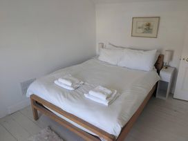 A bedroom with a bed and bedside tables at Fairsands in Portreath