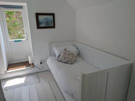 A bedroom with a bed and a door leading outside at Fairsands in Portreath