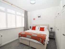 A bedroom with a bed, wardrobe, and bedside table at Portland View in Portland Bill