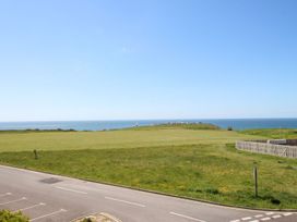 An outdoor view of grassland and ocean at Portland View in Portland Bill