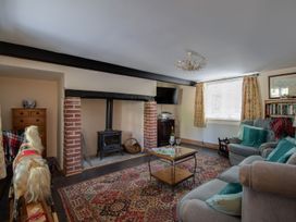 A living room with a fireplace and sofa at Honeypot Cottage in Weymouth