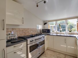 A kitchen with an oven, toaster and microwave at Honeypot Cottage in Weymouth