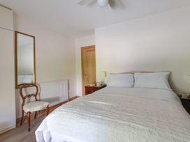 A bedroom with a bed and mirror at Honeypot Cottage in Weymouth