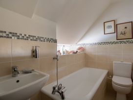 A bathroom with a bath tub and sink at Honeypot Cottage in Weymouth