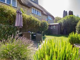 A garden with seating area and shed at Honeypot Cottage in Weymouth