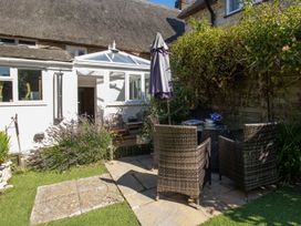 A garden with a table and chairs at Honeypot Cottage in Weymouth