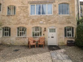 An exterior view of a building with two chairs and a door at Longfords Mill near Nailsworth