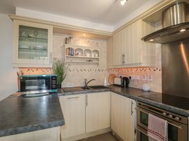 A kitchen with a microwave, sink, kettle, and toaster at Longfords Mill near Nailsworth