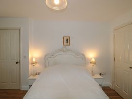 A bedroom with a bed and bedside lamps at Longfords Mill near Nailsworth