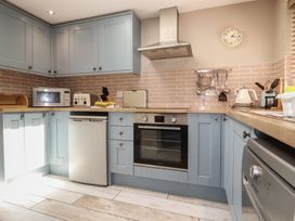 A kitchen with cabinets and appliances at Stowaway Cottage in Padstow