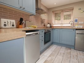 A kitchen with cabinetry, oven, and sink at Stowaway Cottage in Padstow