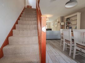 A dining room with a staircase and furniture at Stowaway Cottage in Padstow