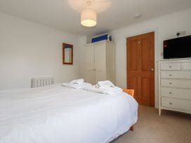 A bedroom with a bed and wardrobe at Stowaway Cottage in Padstow