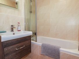 A bathroom with a sink, bathtub, and shower at Stowaway Cottage in Padstow