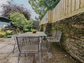 A garden with a table and chairs with plants at Stowaway Cottage, Padstow